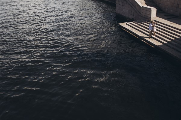 Middle Eastern couple standing on waterfront staircase