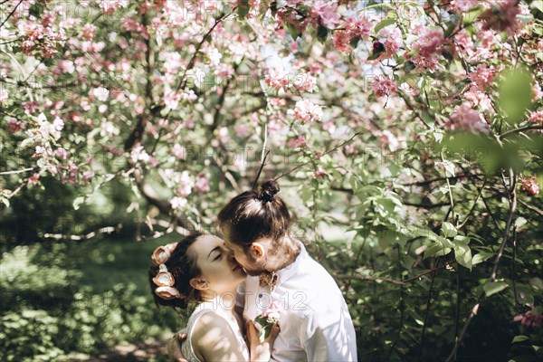 Middle Eastern couple kissing under flowering tree