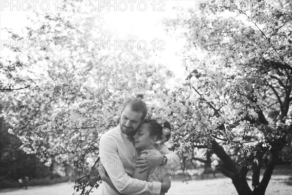 Middle Eastern couple hugging under flowering tree