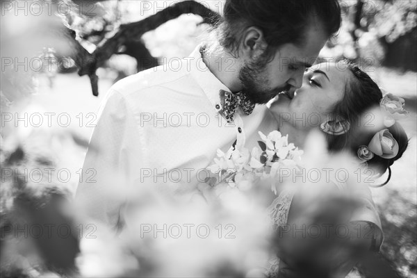 Middle Eastern couple kissing near flowers