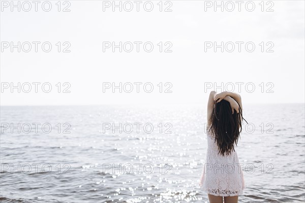 Middle Eastern woman standing near ocean