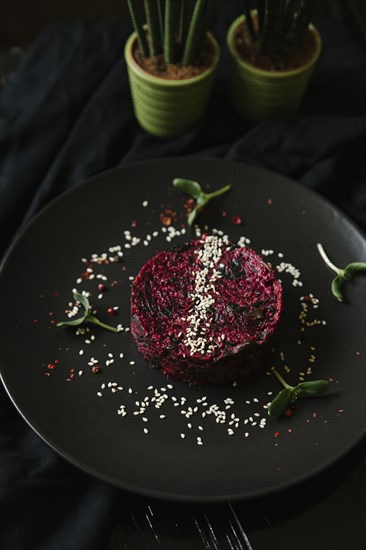 Sesame seeds and garnish on red food on plate