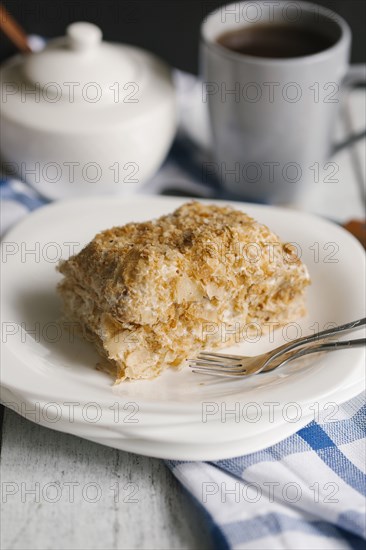 Flaky pastry on a plate with coffee