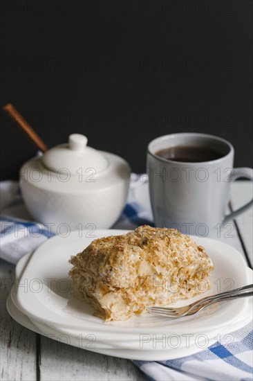 Flaky pastry on plate with coffee