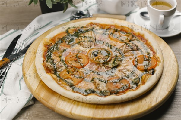 Tomatoes and pesto sauce on pizza