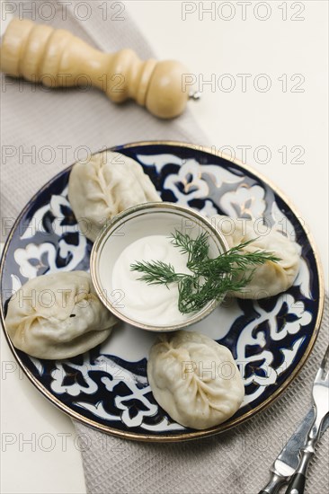 Dumplings and sauce on plate with fork and knife