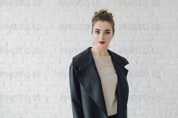 Portrait of glamorous Middle Eastern woman near brick wall