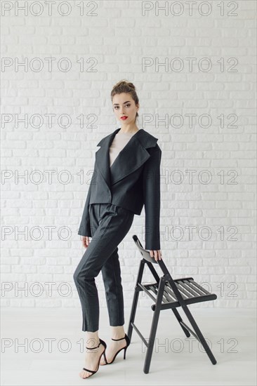 Portrait of glamorous Middle Eastern woman leaning on chair