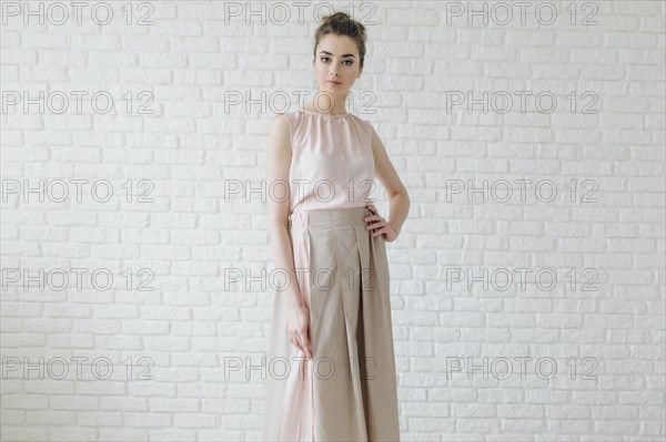 Portrait of glamorous Middle Eastern woman standing near wall