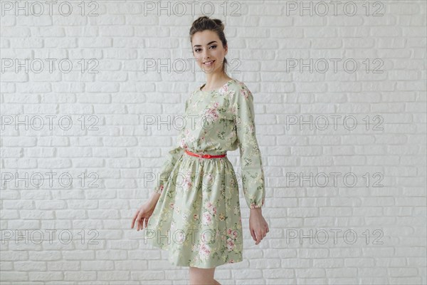 Portrait of glamorous Middle Eastern woman standing near wall