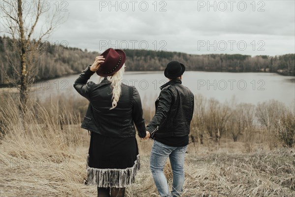 Middle Eastern couple holding hands near lake