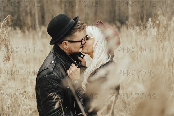 Middle Eastern couple kissing in field