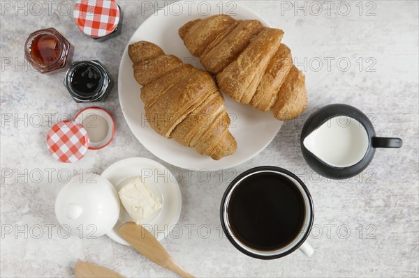 Croissants on plate with coffee and jam