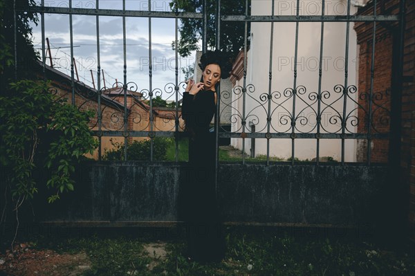 Middle Eastern woman wearing black dress near gate