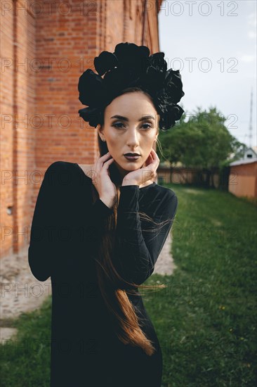 Middle Eastern woman wearing black dress near brick building