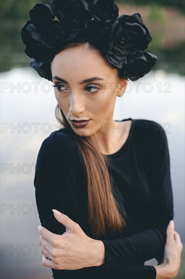 Close up of Middle Eastern woman wearing black dress near lake