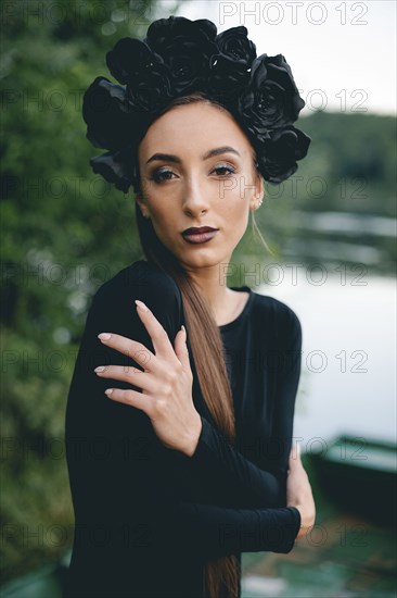 Middle Eastern woman wearing black dress in boat on lake