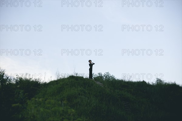 Middle Eastern woman wearing black dress on hill