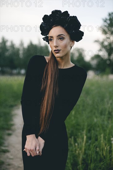 Middle Eastern woman wearing black dress on path in woods