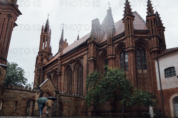 People carrying umbrellas near church