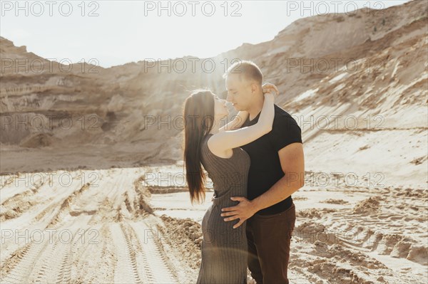 Middle Eastern couple kissing in desert