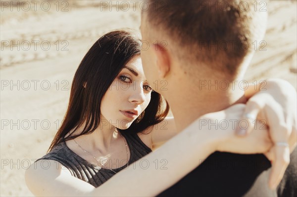 Middle Eastern couple hugging in desert