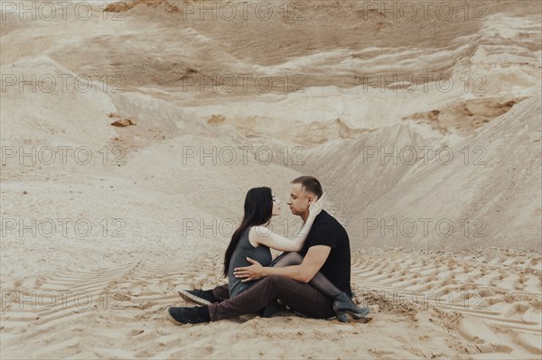 Middle Eastern couple cuddling in desert