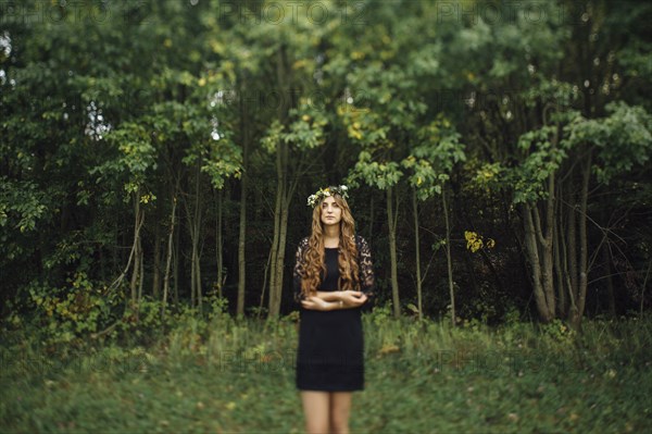 Middle Eastern woman wearing flower crown in woods