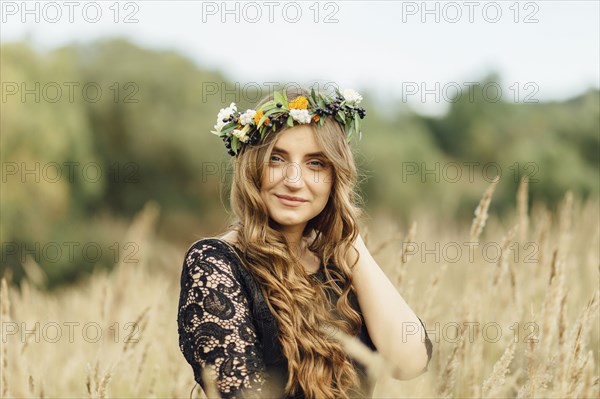 Middle Eastern woman wearing flower crown in field