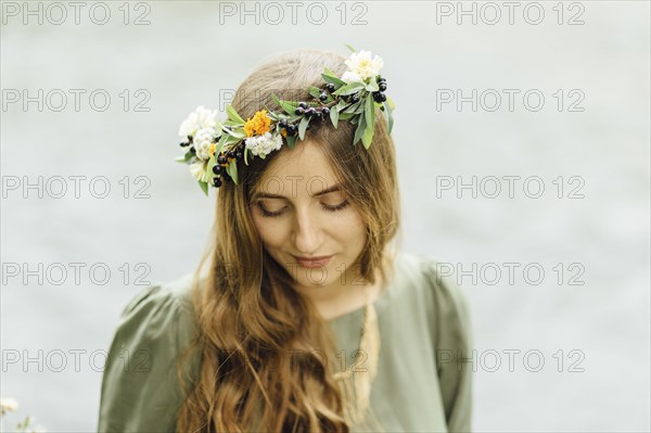 Middle Eastern woman wearing flower crown looking down