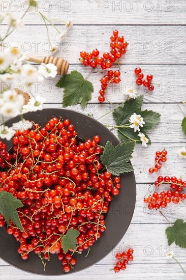 Red berries and leaves on table with flowers