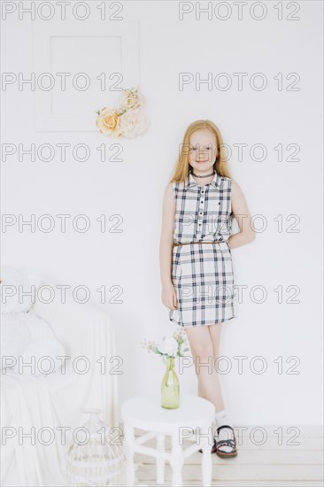 Smiling Middle Eastern girl leaning on wall