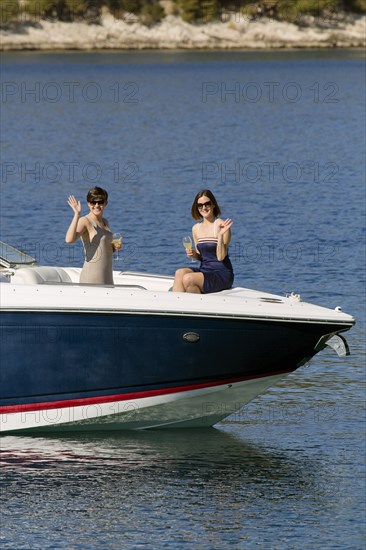 Women waving from boat in ocean