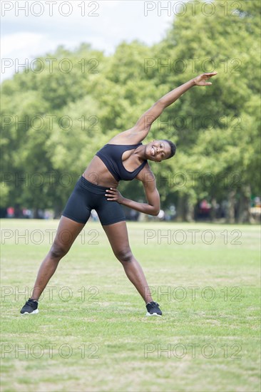 Black athlete stretching in park