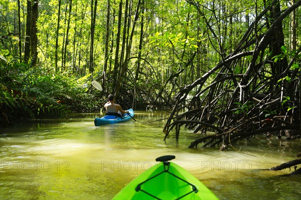 Hispanic woman rowing kayak on river