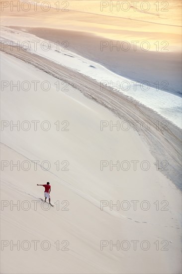 Man surfing on sand dunes on beach