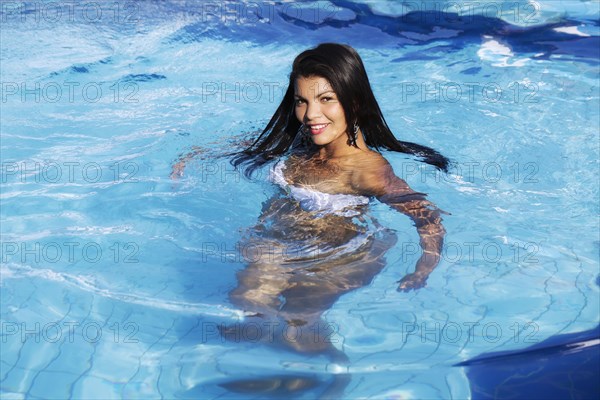Hispanic woman swimming in pool