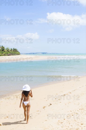 Mixed race woman walking on beach