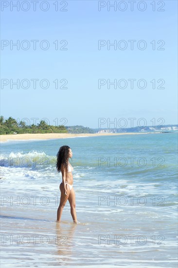 Mixed race woman walking on beach