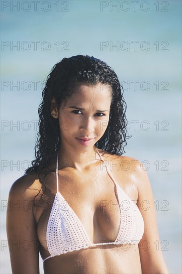 Mixed race woman smiling on beach