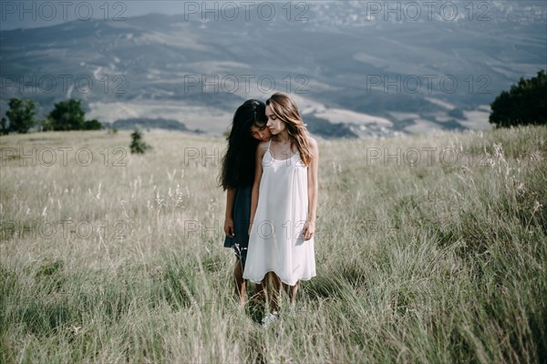 Women standing in field of tall grass