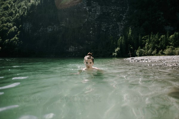 Caucasian woman swimming in mountain lake