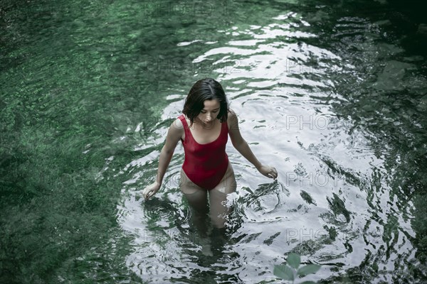 Caucasian woman wading in pool of water