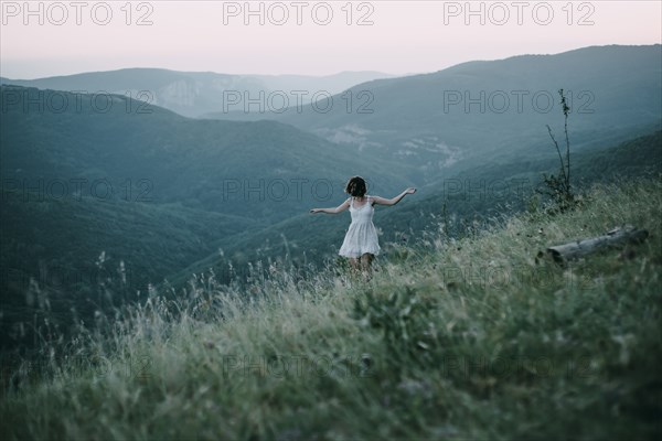 Carefree Caucasian woman walking on mountain