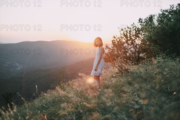 Serious Caucasian woman standing on mountain