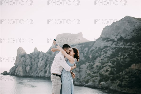 Caucasian man proposing marriage to woman at beach