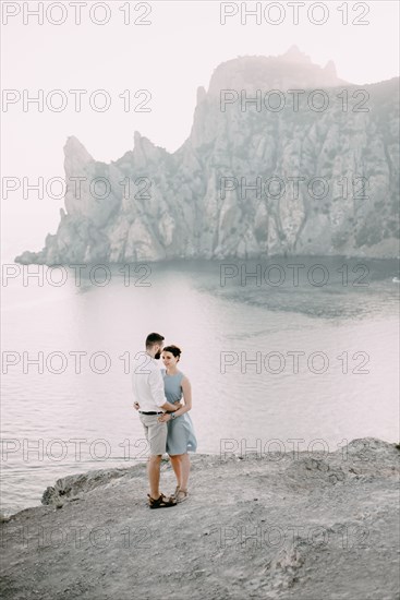 Caucasian man hugging woman at beach