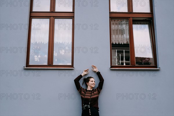 Smiling Caucasian woman leaning on wall