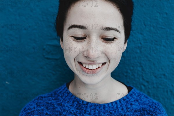 Smiling Caucasian woman near blue wall