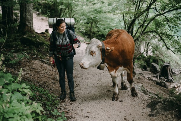 Caucasian woman on forest path with bull